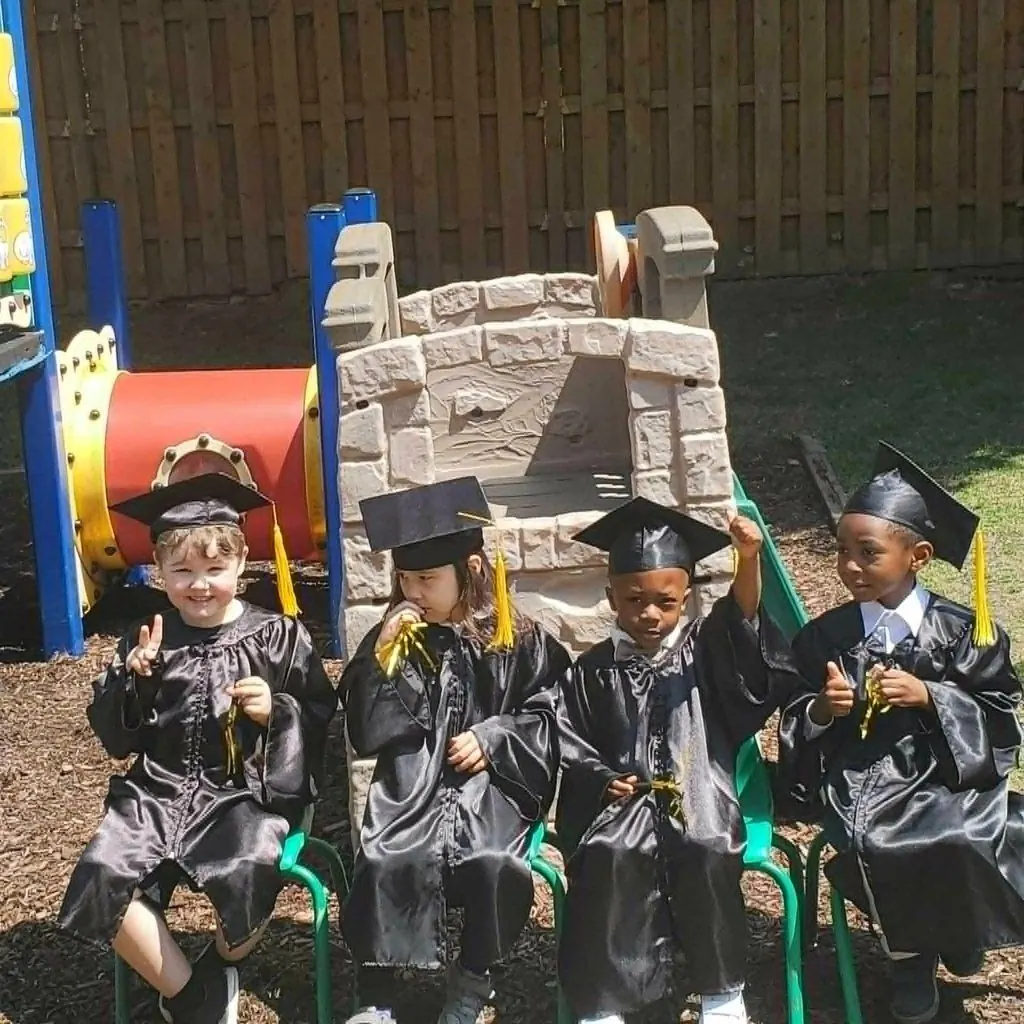Des enfants en toge et mortier de finissants