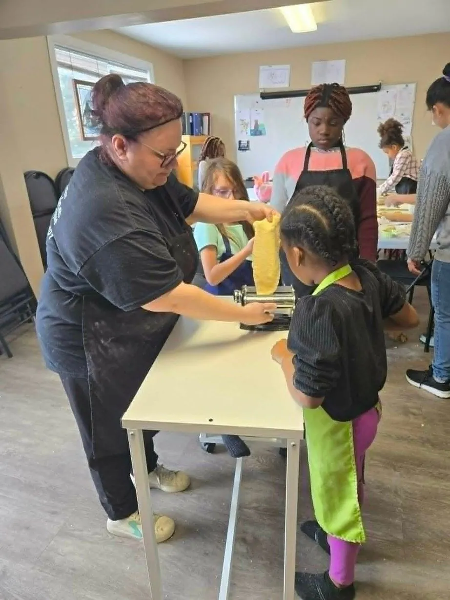 Une animatrice et des jeunes préparent une recette
